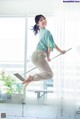 A woman is jumping in the air with a mop.