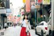 A woman in a red skirt is walking down the street.